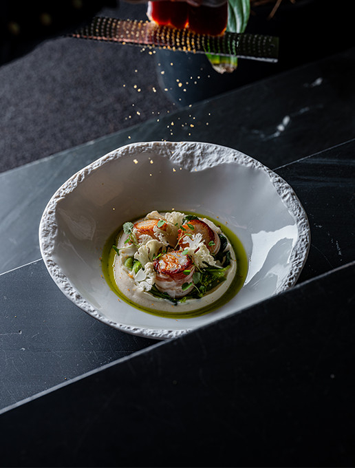 Refined scallop dish garnished with emulsion and crunchy vegetables, served at Dans le Noir ?