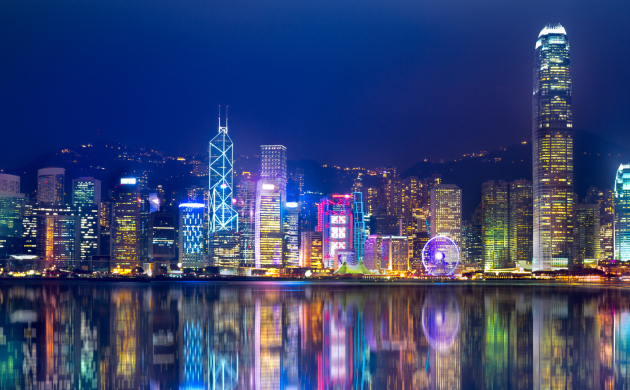 Beautiful evening view of Hong Kong skyline with illuminated skyscrapers and Victoria Harbour under twilight sky